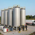Löschwasserzisterne für Industriehalle in einer modernen Industrieanlage mit Mitarbeitern, die Brandschutzlösungen bewerten.