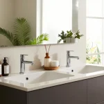 Moderne badmeubel in een stijlvolle badkamer met dubbele wastafels en elegante decoratie.